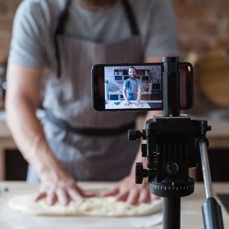 photo d'un artisan boulanger en train de se filmer alors qu'il prépare un pain