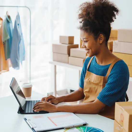 une jeune femme consulte son e-commerce sur un ordinateur portable