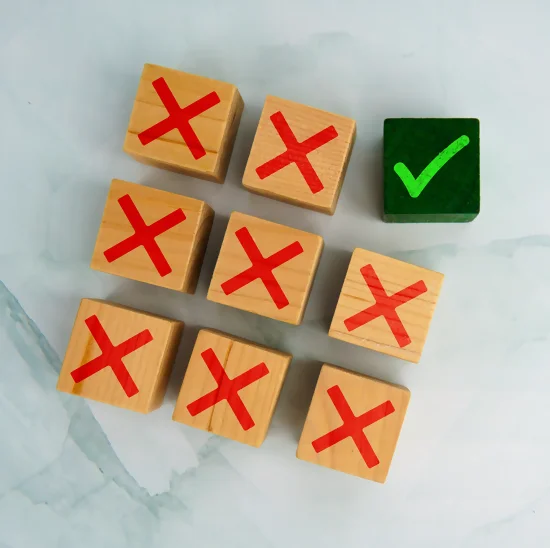 Cubes en bois avec des croix rouges et une coche verte représentant un choix